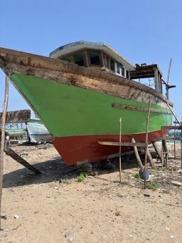 Steel vessel hull coated with red antifouling paint